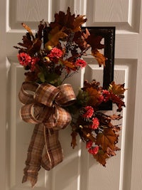 a fall wreath hanging on a door