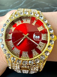 a person wearing a red watch with diamonds on it