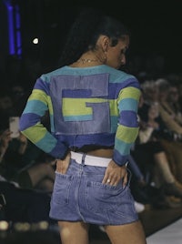 a woman on the runway wearing denim shorts and a striped sweater