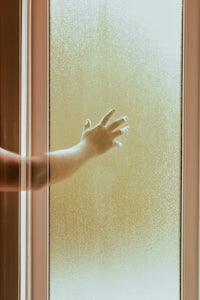 a person's hand reaching out of a window