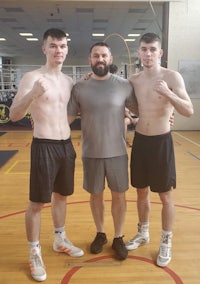 three young men posing for a picture in a gym