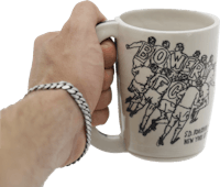 a hand holding a mug with a drawing of a football team
