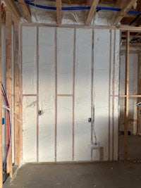 an unfinished room with insulation and pipes