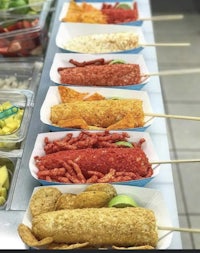 a line of trays with different kinds of food on them