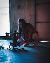 a woman is kneeling down in front of a camera
