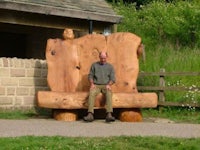 a man sitting on a large wooden bench