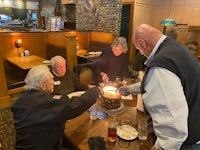 a group of people lighting a cake in a restaurant