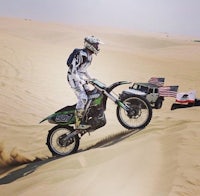 a person riding a dirt bike on a sand dune