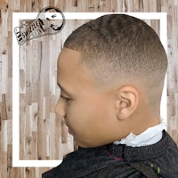 a boy's haircut with a shaved head on a wooden floor
