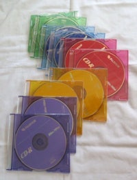 a set of colorful cd cases on a white bed
