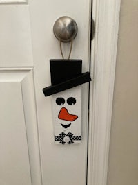 a door hanger with a snowman on it