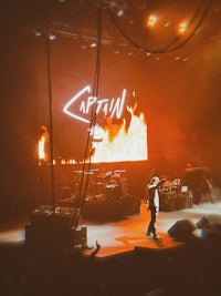 a man standing on a stage in front of a fire