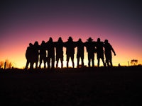 silhouettes of a group of people at sunset