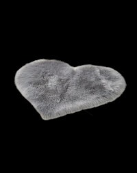 a grey heart shaped rug on a black background