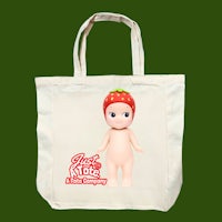 a tote bag with a strawberry doll on it
