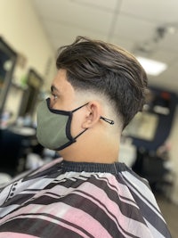 a man wearing a face mask in a barber shop