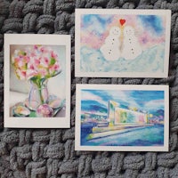 three watercolor cards with flowers and snowmen on them