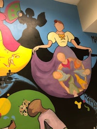 a mural depicting a woman in a dress and a man in a hat
