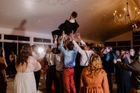 a man is being thrown into the air at a wedding reception
