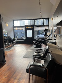a hair salon with chairs and a sink