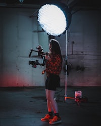 a woman holding a camera in front of a light