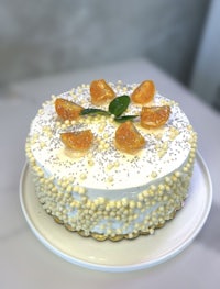 a cake with oranges on top of a white plate