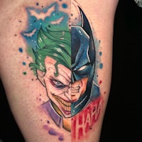 a tattoo of batman and joker on a thigh