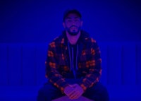 a man sitting on a couch in front of a blue light