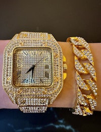 a woman's wrist with a gold watch and bracelet