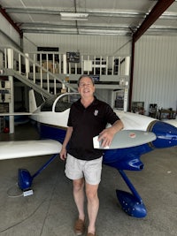 a man standing next to a blue and white airplane
