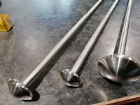 three stainless steel pipes on a table