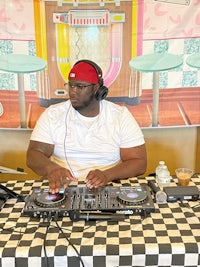 a man is djing at a table in front of a checkered tablecloth