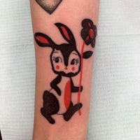 a tattoo of a bunny holding a flower