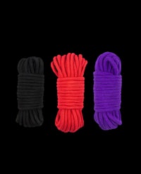 three different colored ropes on a black background
