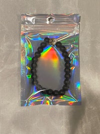 a black beaded bracelet in a clear plastic bag