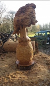 a wooden sculpture of a mushroom sitting on top of a pile of wood