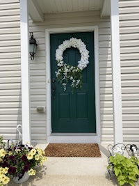 a green front door with flowers on it