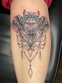 an owl tattoo on a woman's thigh