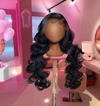 a mannequin with long wavy hair in a pink room