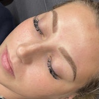 a woman with long eyelashes and eyebrows in a salon