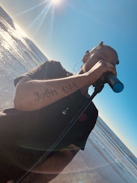 a man holding a microphone on the beach
