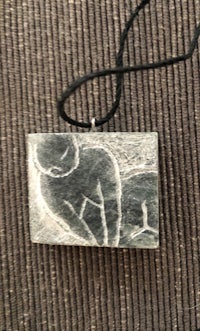 a necklace with an image of a woman holding a baby