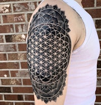 a man with a flower of life tattoo on his arm