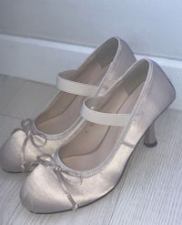 a pair of women's shoes with bows on them