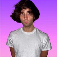 a young man in a white t - shirt standing in front of a purple background