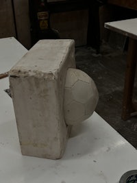 a soccer ball is sitting on top of a concrete block