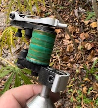 a person holding a tattoo machine in the woods