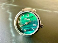 a green watch with the word goma on it