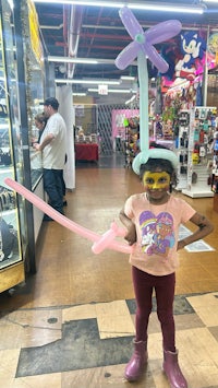 a young girl holding a balloon in a store