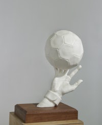 a sculpture of a hand holding a soccer ball